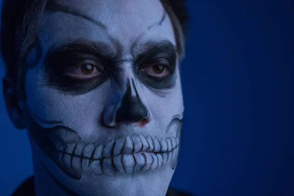 Porträtt av en ung man med en skalle makeup till Halloween på svart bakgrund — Stockfoto