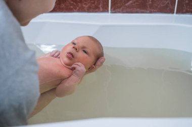 Bebek için yüzme sağlık. Kız bebek masaj sıcak suda yapıyor. Watsu terapi