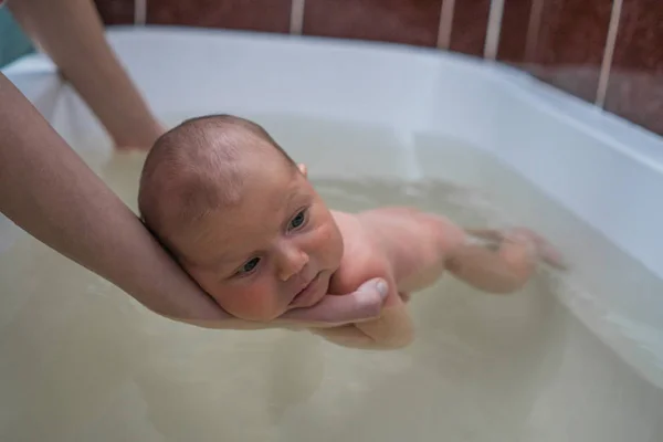 Terapia infantil en agua tibia. Bañar al bebé en el baño —  Fotos de Stock