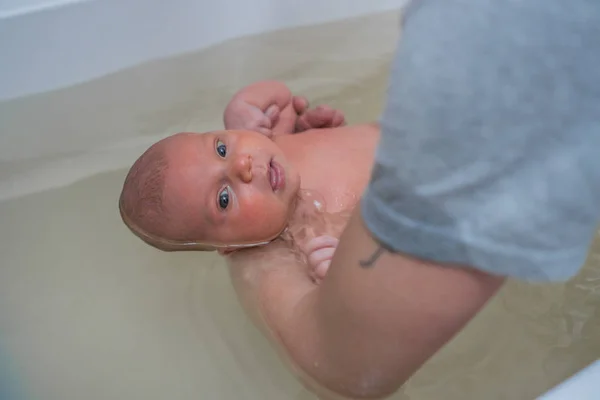 Terapia infantil en un baño caliente. Bañar al bebé en el baño del bebé. Masaje bebé —  Fotos de Stock