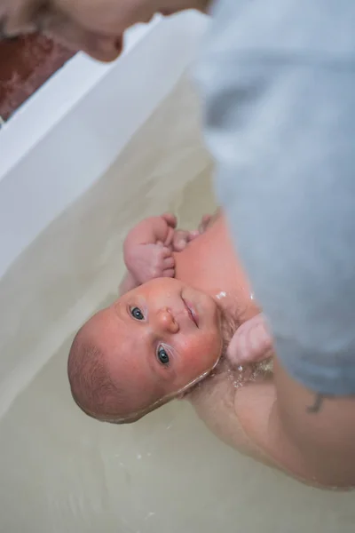 Una mujer sosteniendo a un bebé, bañándose en un baño caliente. Terapia Watsu . —  Fotos de Stock