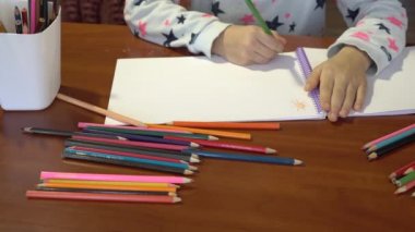 Yakın çekim çocuk eller, çocuk beyaz bir kağıda renkli kalemler çizer. Çocuk yaratıcılık