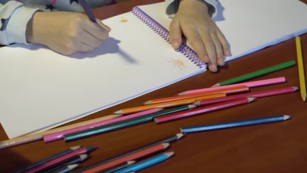 Gros plan des mains des enfants, l'enfant dessine des crayons de couleur sur une feuille blanche . — Video