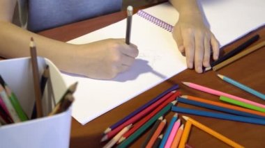 Yakın çekim Childs'ı el ile renkli kalemler çizim. Masa üstü görüntüsü üzerinde yaratıcı karışıklık