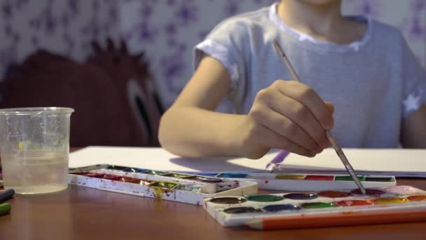 A criança desenha com um pincel aquarela no álbum. Criatividade infantil. Imaginação infantil — Vídeo de Stock