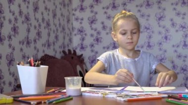 Küçük şirin ışık kız odasında bir albümdeki boyar. Çocuk yaratıcılık