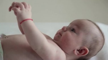 Güzel bebek bacakları sallayarak onun arkasında yatan