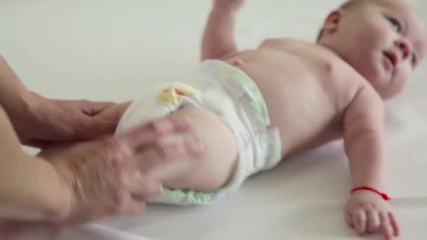 Mutter massiert seine Babys Beine mit einem lustigen Gesicht — Stockvideo