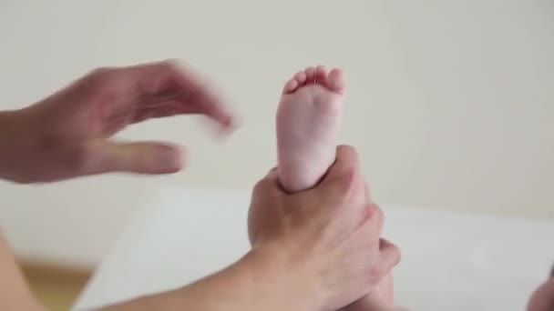 妈妈用一张滑稽的脸按摩他的孩子的腿 — 图库视频影像