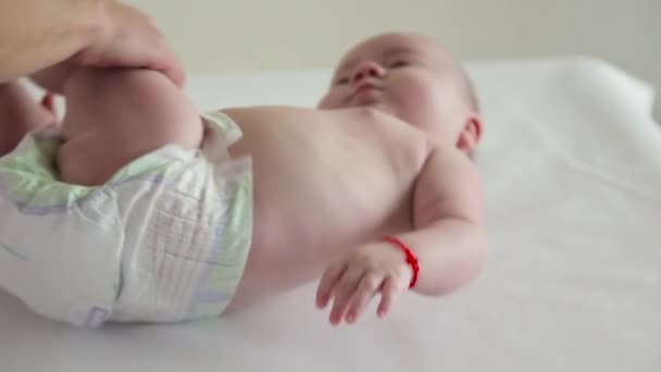 Mamá masajea sus piernas de bebé con una cara divertida — Vídeos de Stock