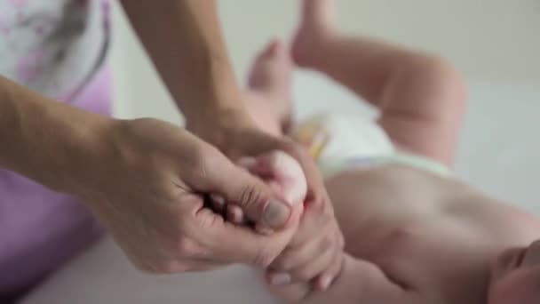 Mama massiert den Fuß der Babys aus nächster Nähe. Babymassage — Stockvideo