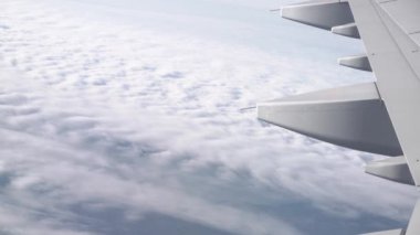 Bulutların üzerinde hava yoluyla seyahat. Kabarık bulutlar uçak penceresinden görünümü