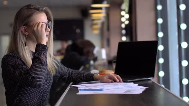 Freelancer mujer trabajando con un ordenador portátil en una cafetería, vista de cerca — Vídeos de Stock