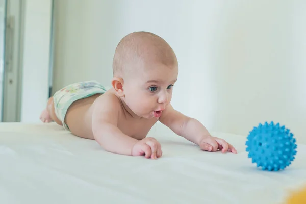 Sürpriz sevimli küçük bebek oyuncak topu için ulaşır. Bebekler ile Oyunlar — Stok fotoğraf