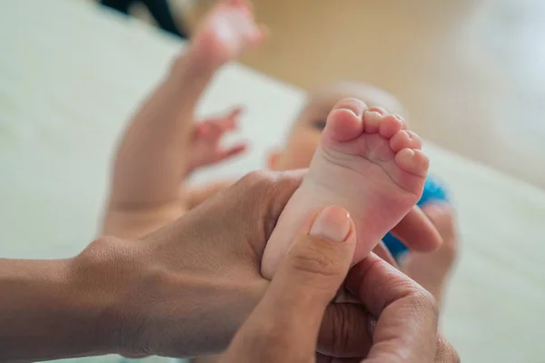 Zbliżenie małych nóg Childs w kobiecych rękach. Opieka rodzicielska dzieci. Koncepcja rodziny — Zdjęcie stockowe