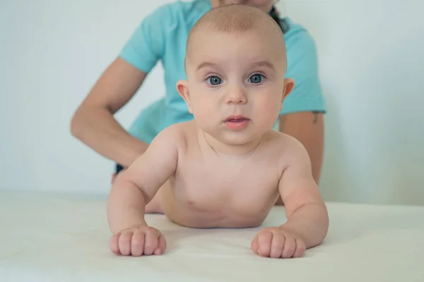 一个可爱的小宝宝的肖像,大美丽的眼睛。给小孩按摩的女人婴儿按摩 — 图库照片