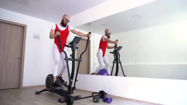 4k lustiger Mann in Leggings und Body ist im Simulator in der Halle mit Spiegeln beschäftigt. — Stockvideo