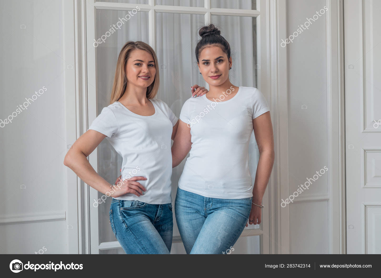 Udvidelse Omgivelser sfære Portræt af sød blondine og brunette i blå jeans og hvide t-shirts. Modellen  af logoet på en hvid t-shirt . — Stock-foto © 2735369.mail.ru #283742314
