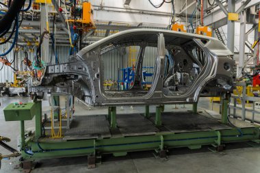 Araba montaj fabrikasında üretim hattında metal araba gövdesi.