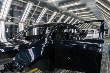 Araba fabrikasında boya yaptıktan sonra cesedin yakın çekimini yapın. Makine montajı üretimi