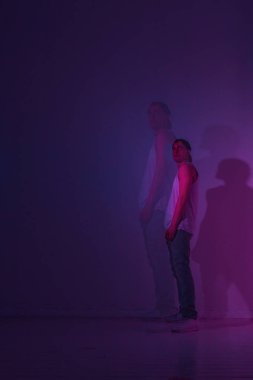 Guy renkli ışık ile bir Stüdyo'da bir hip hop dansçısı. Çift pozlama fotoğraf