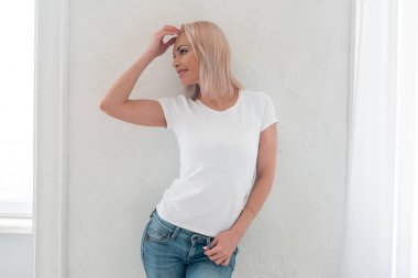 Hafif bir arka plan üzerinde beyaz bir t-shirt güzel bir kız Nazik portre