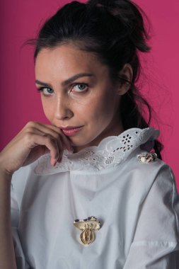 Beyaz moda gömlekli güzel bir kızın kameraya yakından bakan yakın çekim portresi.