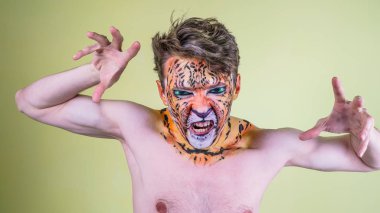 Parlak bir arka plan üzerinde bir kaplan boyalı yüzü olan adam