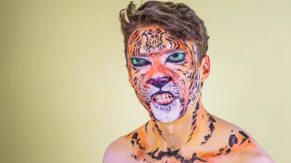 The guy with the painted face of a tiger on a bright background — Stock Photo, Image