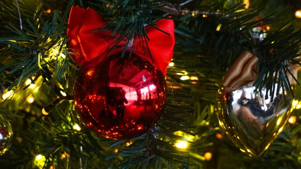 Fechar - para cima de uma bola vermelha brilhante na árvore de Natal. A decoração da árvore de férias. Contexto — Fotografia de Stock