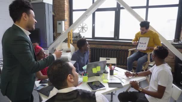 Een team van jonge specialisten van aandeelhouders bestudeert de beleggingsgrafieken van de valutamarkt. Brainstormen. Teamwork. — Stockvideo