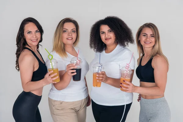 Jeunes filles mignonnes tenant des lunettes avec du jus naturel. Une alimentation saine et adéquate. Perte de poids et gain de poids — Photo