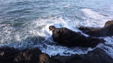 Gelgit geçişli. Dalgalar kayaların üzerinde beat