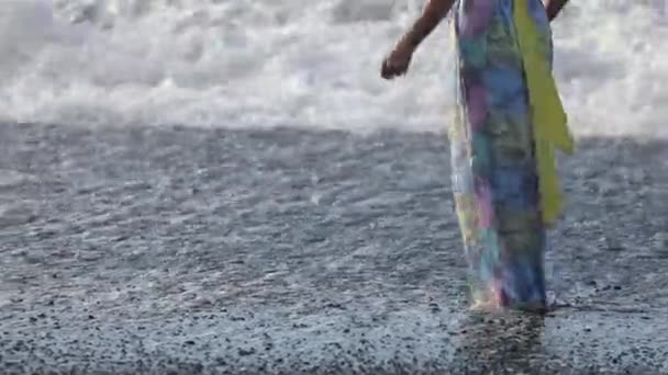 ドレスを着た若い女性が踊り 黒いビーチの上を歩きます 海岸に実行します アイスランド — ストック動画