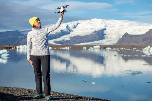 Genç kadın quadcopter başlattı. Gadget'ı arka plan güzel mavi dağlar ve buz kadınla