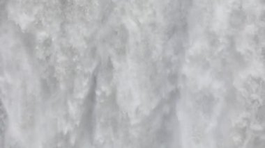 Güçlü azgın whitewater şelale zorla kayalık bir kenarın üzerine düşüyor. Kristal berraklığında buzul su akışı uçurumdan düşüyor