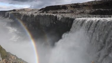 Güçlü azgın whitewater şelale zorla kayalık bir kenarın üzerine düşüyor. Kristal berraklığında buzul su akışı uçurumdan düşüyor