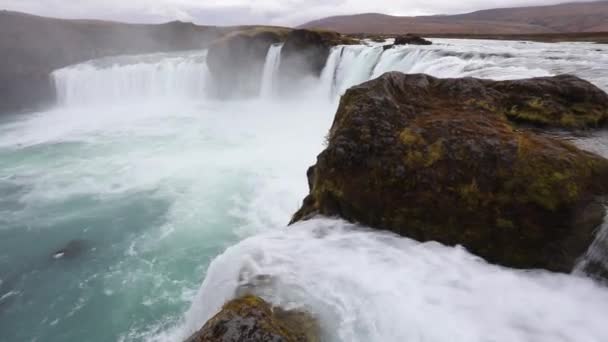 強力な荒れ狂う急流の滝岩のエッジ上強制的に落下します 崖から落として透明な氷河水の流れ — ストック動画