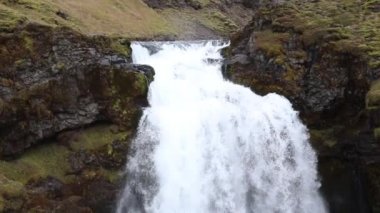 İzlanda şelale Dağları arka plan üzerinde. Su Streams uçurumdan düşmek ve aşağı düşer. Ağır çekim