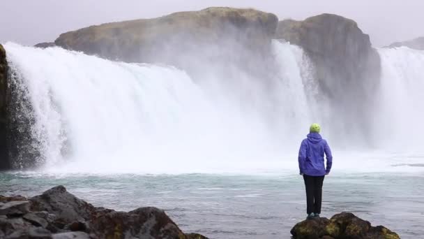 Eine Junge Frau Bewundert Einen Mächtigen Reißenden Wasserfall Der Schwer — Stockvideo