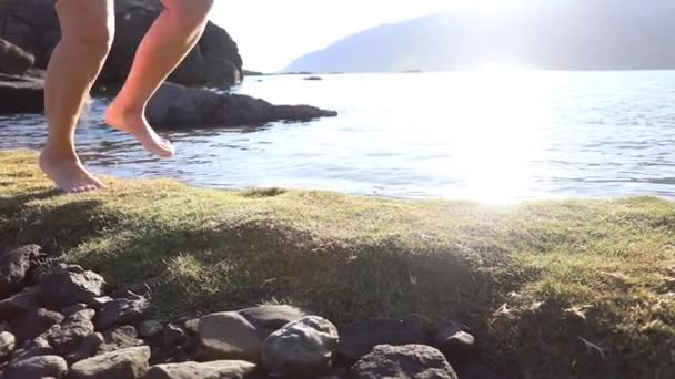 Girl Runs Barefoot Green Beach Moss Sun Rays Reflected Water — Stock Video