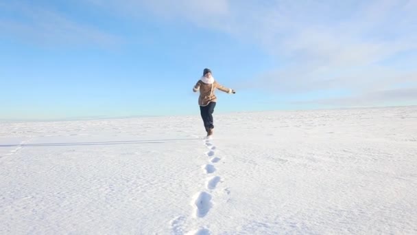 Een Jong Meisje Gaat Vrolijk Springt Een Veld Met Sneeuw — Stockvideo