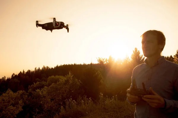Bir adam quadcopter başlattı. Dron nehir ve orman üzerinde uçan güneşli bir günde