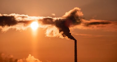 Soğutma kuleleri buğulaması ve günbatımı degrade gökyüzü karşı endüstriyel yığınları Sigara