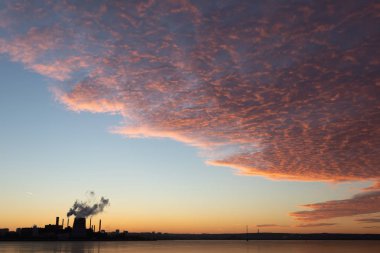 Fabrika borular atmosfere kirlilik yayan bir bakış. Çevre sorunları. Kırmızı günbatımı güneş