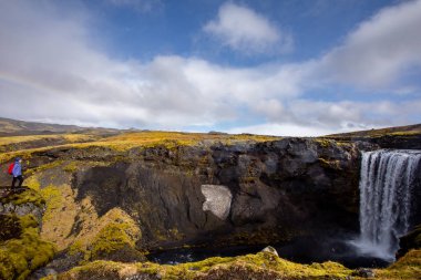 İzlanda'daki bir şelale manzarası. Su tepeden aşağıya doğru akar..