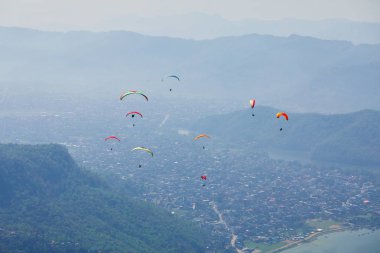 Uçan bir Yamaçparaşütü üzerinde. Güzel manzara dağlar ve renkli paraşütler ile. Aşırı tatil seyahat