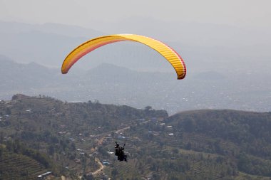 Uçan bir Yamaçparaşütü üzerinde. Güzel manzara dağlar ve renkli paraşütler ile. Aşırı tatil seyahat
