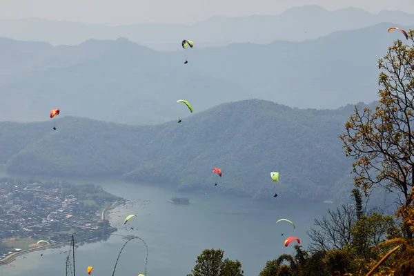 在滑翔伞上飞行 美丽的景色与山脉和五颜六色的滑翔伞 极端度假旅行 — 图库照片