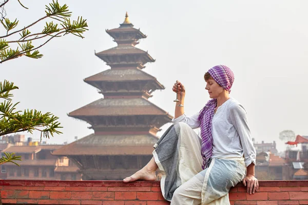 若い女性は 鐘塔の背景に瞑想です ネパール — ストック写真